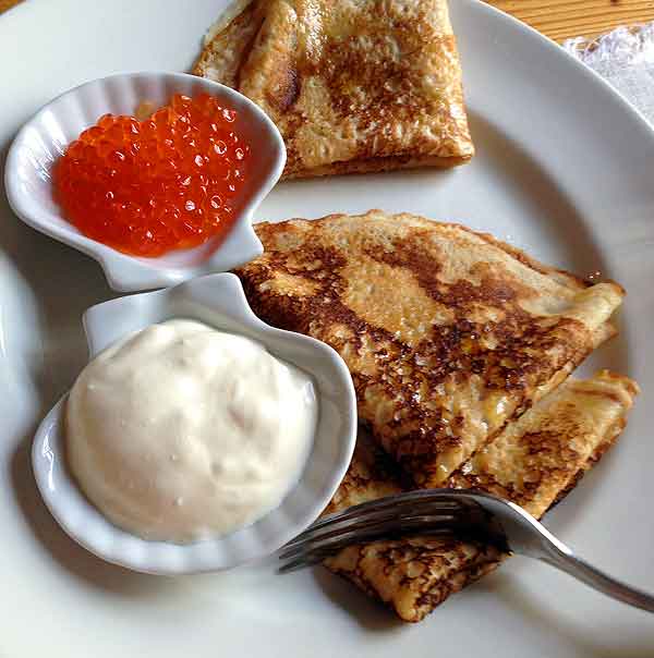 Vodka and caviar in Russia: Red salmon caviar, sour cream, and perfect pancakes