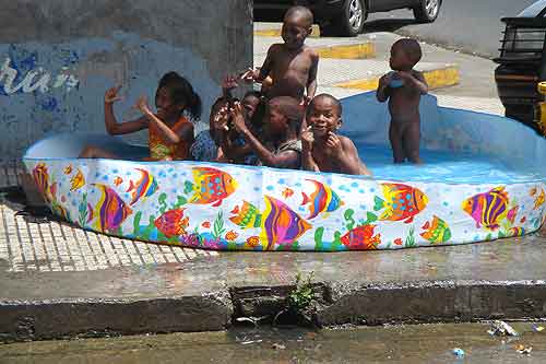 Colon kids cool off in a pool on a street corner.