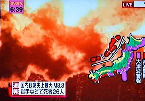 Superimposed on images of fire, a map of Japan shows tsunami warnings in purple.