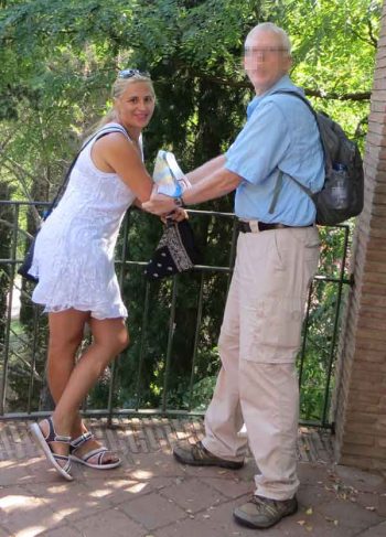 Pickpockets look like tourists. The man just witnessed this woman stealing his wife's wallet. He grabbed and held onto the pickpocket.