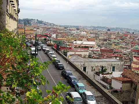 View from a low hotel window: our hotel on left, mountain road, and the city.