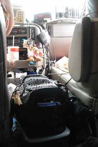 The front seat, floor, between the seats, and dash were crowded with the driver's personal items.