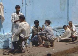 Streetside barbers in Mumbai\'s blistering noon sun.