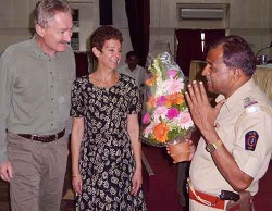 Street crime in Mumbai, India: Senior Police Inspector Bhawale presents Bob Arno and Bambi with a thank-you bouquet.