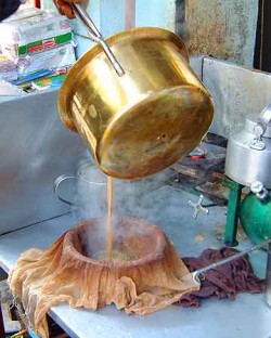 Tea leaves and spices are strained out with a cloth.