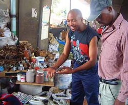 Mondli and Hector purchase herbs from a witchdoctor at a South Africa muti market.