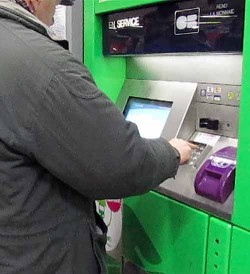 A man enters his PIN while buying Metro tickets with a credit card.