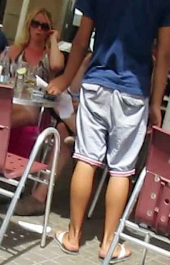 Theft-proof vacation. The young pickpocket tries to nab the phone one-handed under his paper. (Frame grab from video.)