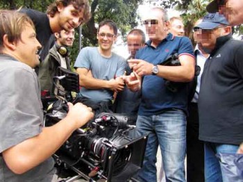 Van Royko, our director of photography, shows the last take on a monitor. Pickpocket crew and film crew crowd in to watch.