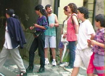 The two women at left are pickpockets. The two boys at right are their stalls. The woman at center was the intended victim.